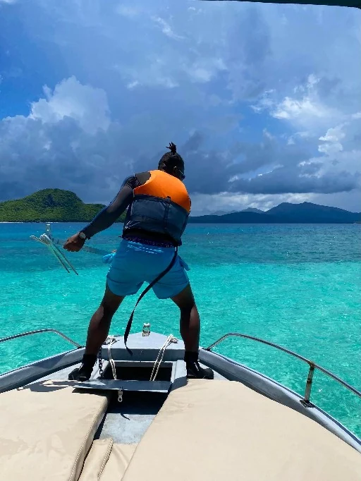 Personne à l’avant d’un bateau sur le lagon